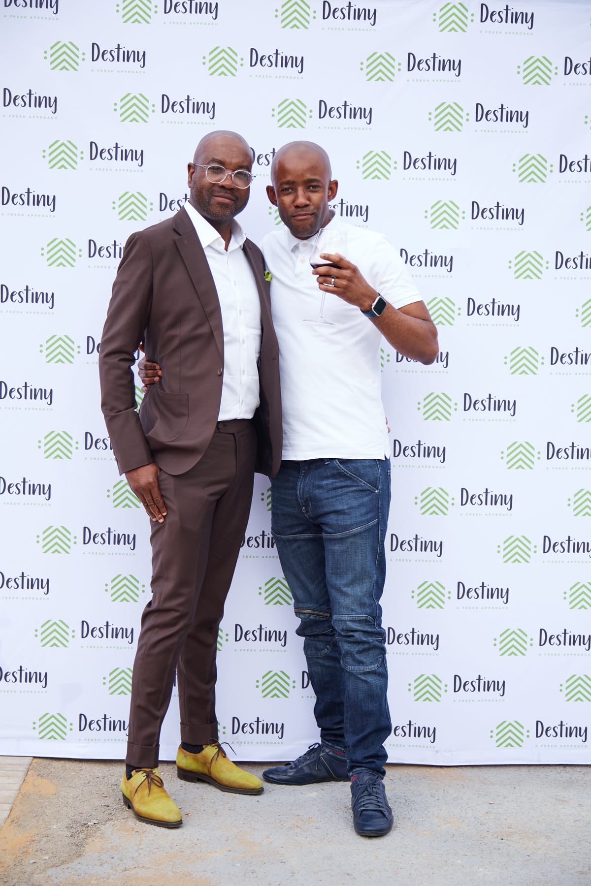 Two men pose together in front of a 